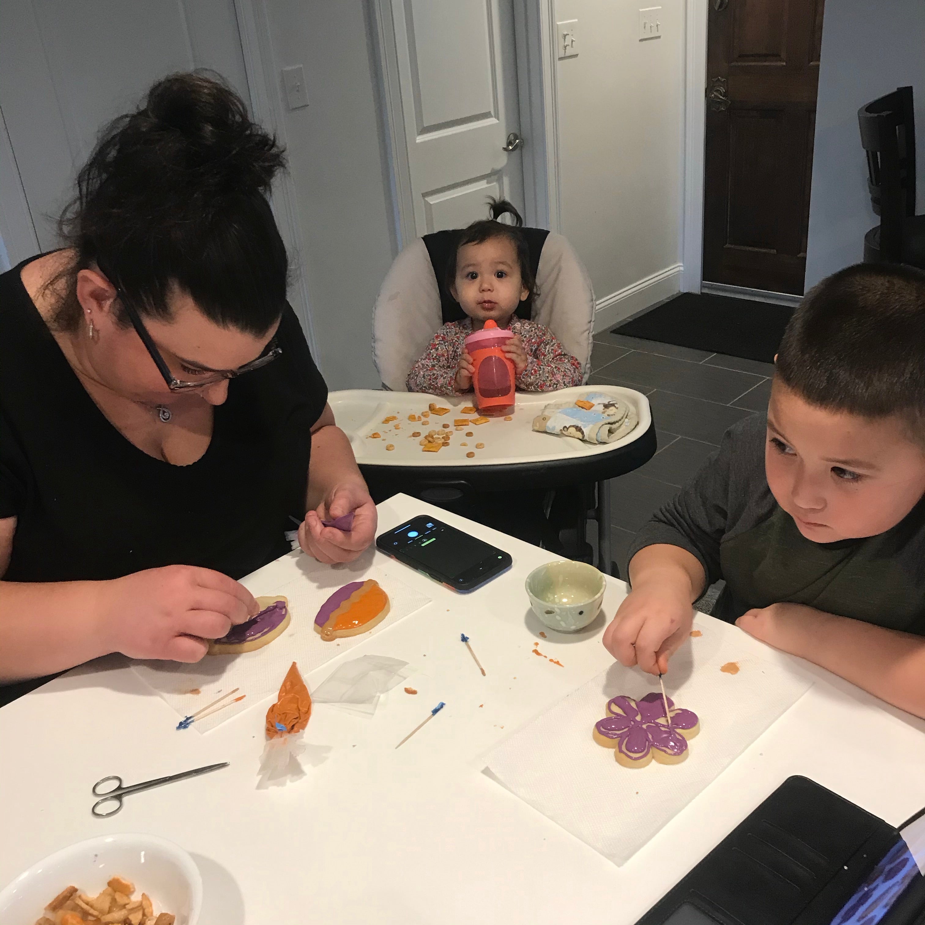 DIY sugar cookie decorating kits to do at home featuring a family decorating their own sugar cookies.