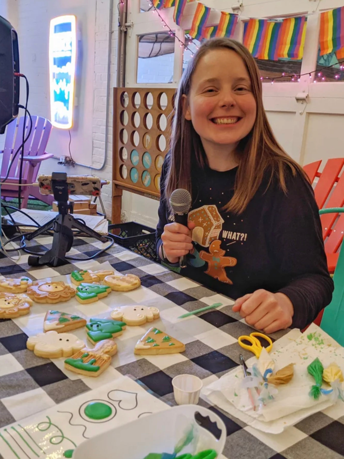 Veronica founder of The Cookie Lady's Daughter decorates cookies at a table.