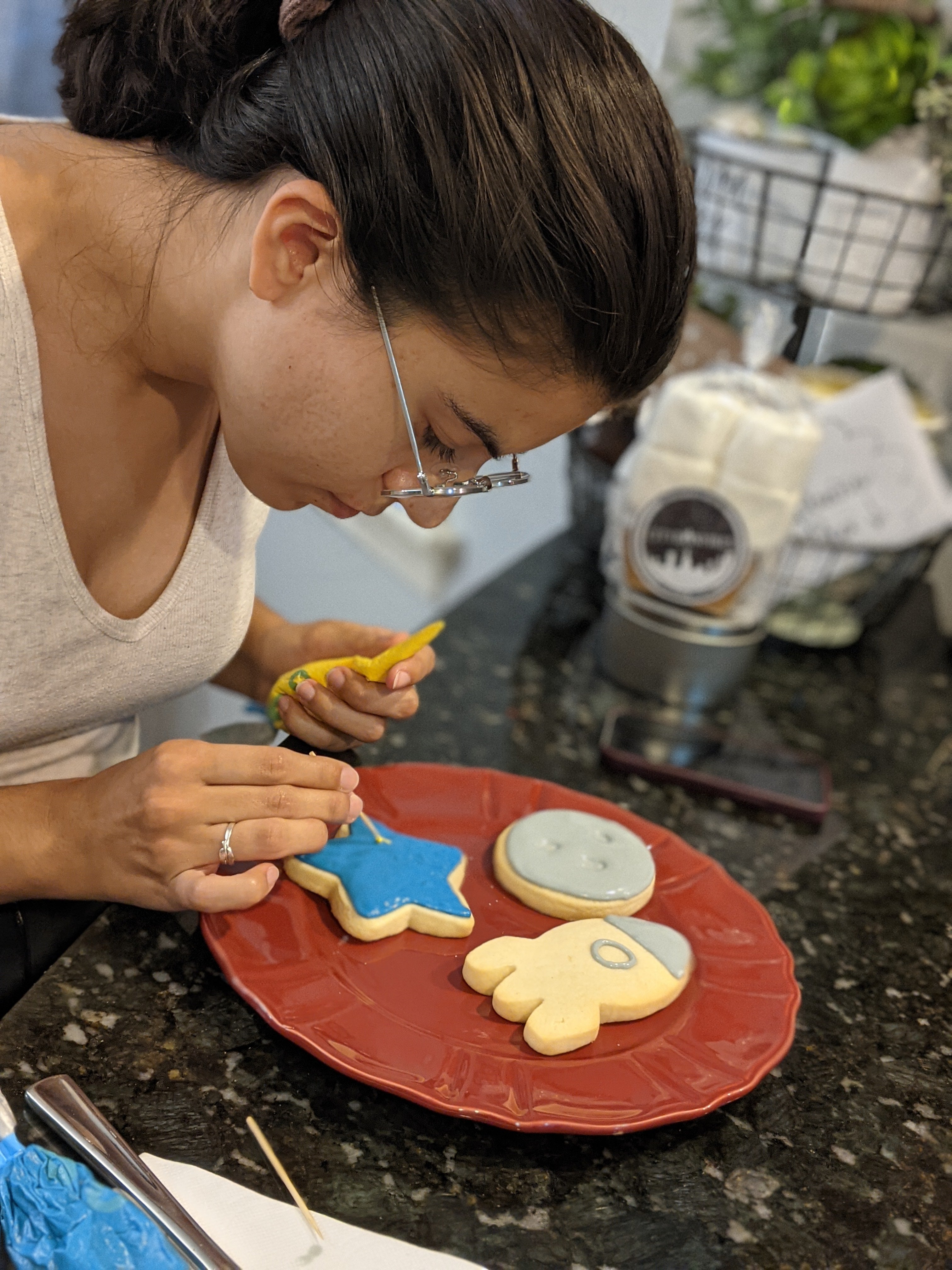 Decorate your own sugar cookies featuring a young woman painting a blue star.